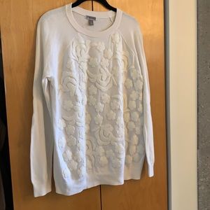 Cream sweater with embroidered detail.